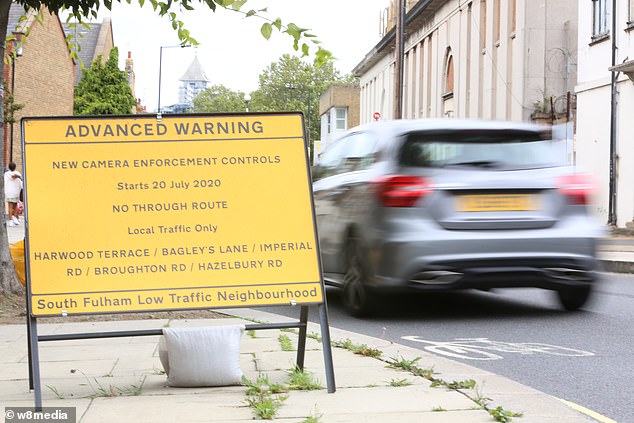 Hammersmith and Fulham Council has introduced a new scheme only allowing local residents to drive through certain roads. A sign above warns of the 