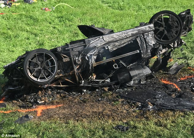 Shocking: Amazon later released this image showing the burnt-out wreckage of the car laying upside down on a hill