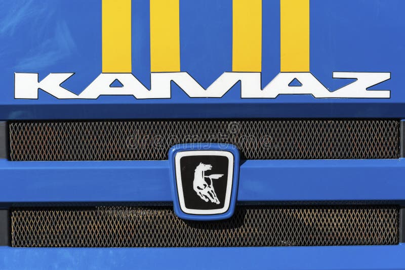 Badge and logotype of Russian truck KAMAZ on front car cabin. KAMCHATKA, RUSSIA - OCT 2, 2018: Badge and logotype of truck KAMAZ and sticker orange-blue stripes stock image