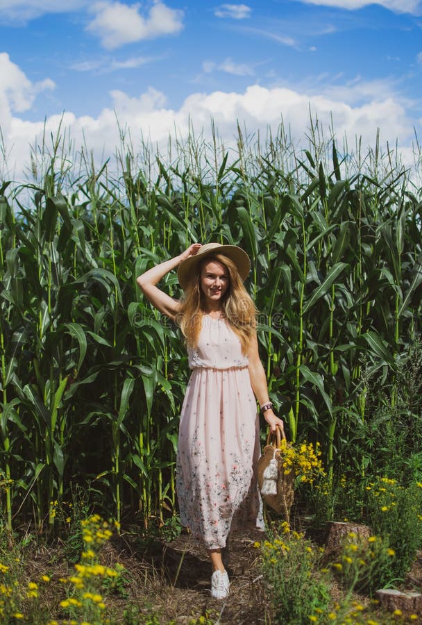 Beautiful woman with long blond hair in hat walking in cornfield. Summer, Latvia, vintage royalty free stock photos