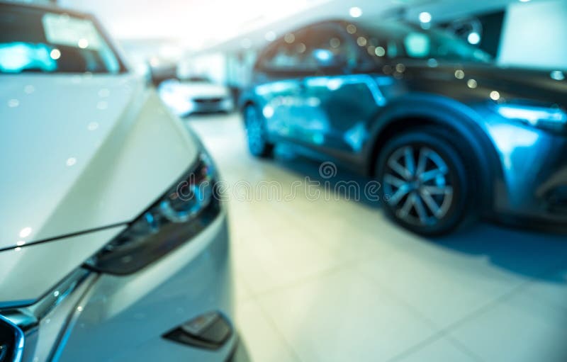 Blurred SUV car parked in modern showroom. Car dealership and auto leasing concept. Automotive industry. Modern luxury showroom. Front view new car parked in royalty free stock photo