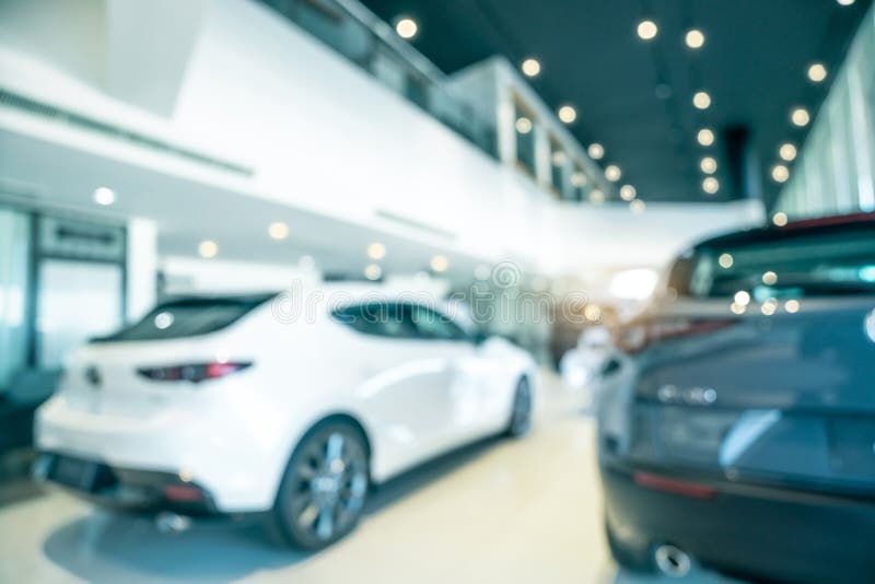 Blurred SUV car parked in modern showroom. Car dealership and auto leasing concept. Automotive industry. Modern luxury showroom. Rear view new car parked in stock photo