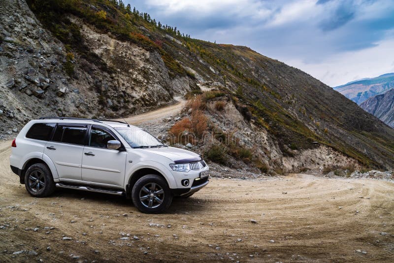 A car going down a mountain road from the Katu-Yaryk pass to the valley of the Chulyshman river. Ulagansky District, Altai Republic, Russia royalty free stock images