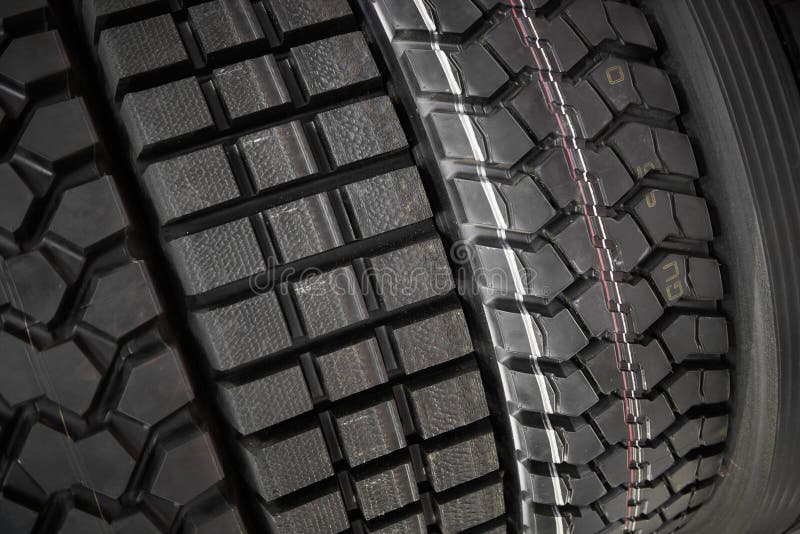 Close up view on heavy trucks and tractors new wheel tires surface. Different pattern and type tires for automotive industry comme stock photography