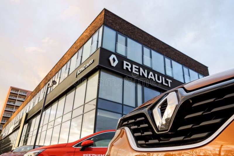 The detail of barge and frontal part of orange Renault Captur SUV in front of the Dacia - Renault dealership which sells these. OSTRAVA, CZECH REPUBLIC stock photo