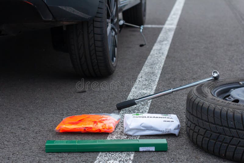 First aid, safety orange vest and green road sign on a asphalt road on the background of a broken car. Emergency tool kit for the. First help after car accident royalty free stock image