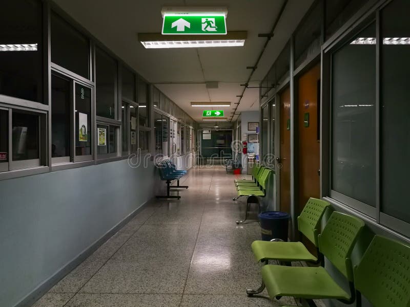 Green emergency exit sign in hospital showing the way to escape at night royalty free stock photos