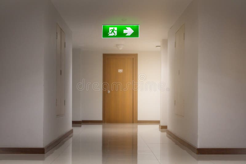 The​ green emergency exit sign in hotel showing the way to escape. Green emergency exit sign in hotel showing the way to escape royalty free stock images