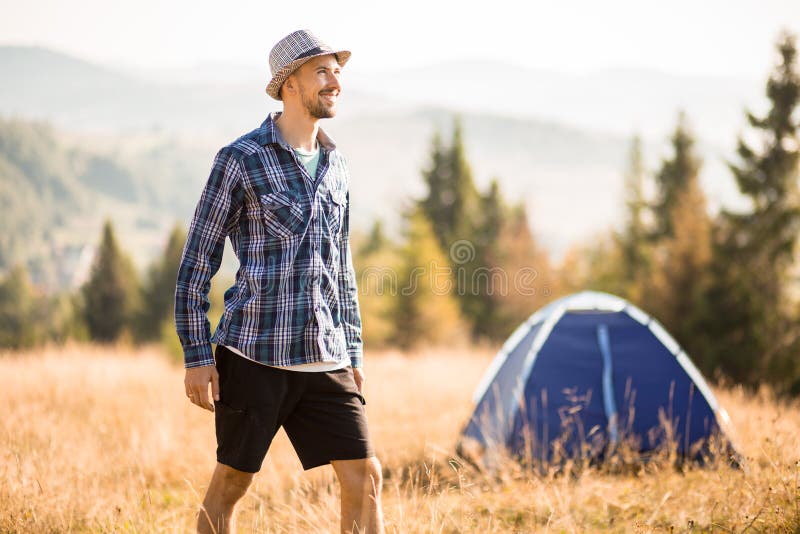 Happy bearded man in hat enjoying ecotourism on top of mountains. Concept of hiking lifestyle stock photos