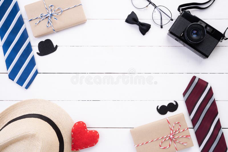 Happy fathers day concept. Top view of blue tie, beautiful gift box, man hat with glasses and retro film camera on white wooden. Table background. Flat lay royalty free stock photos