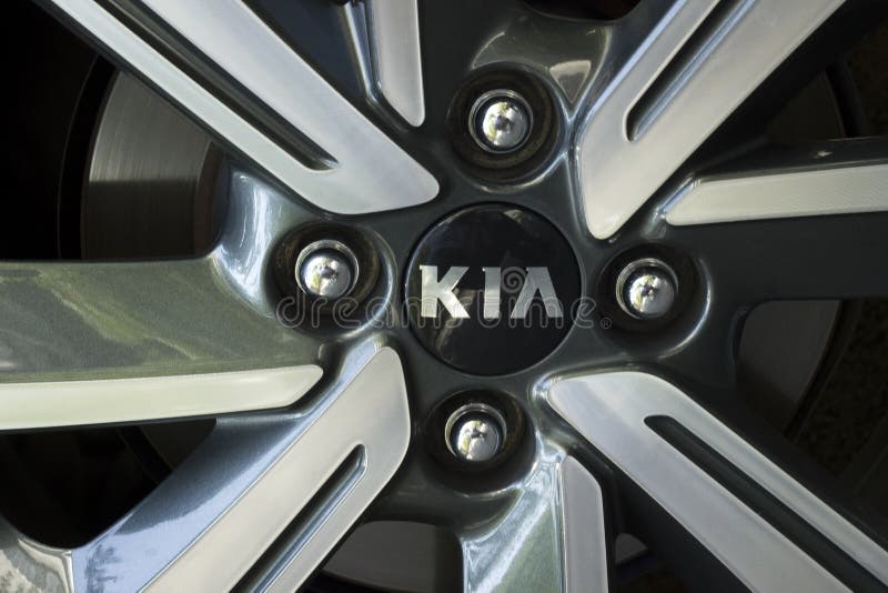 Kia, emblem on a car wheel. Kia car wheel fragment with nuts and badge stock images
