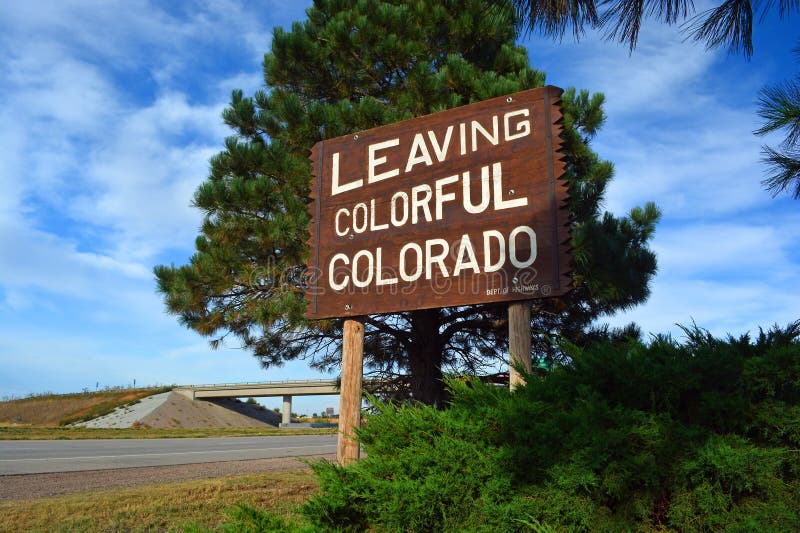 Large Leaving Colorful Colorado Wooden Roadside Highway Sign on a Sunny Day stock photo