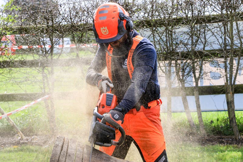 A man sawing wood using electrical chainsaw. royalty free stock images