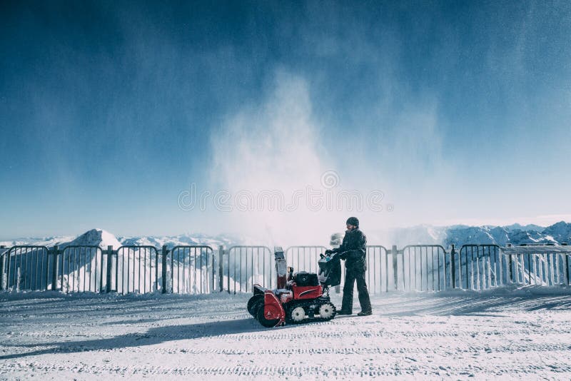 Man working with snow blowing machine in mayrhofen ski area, austria royalty free stock photo