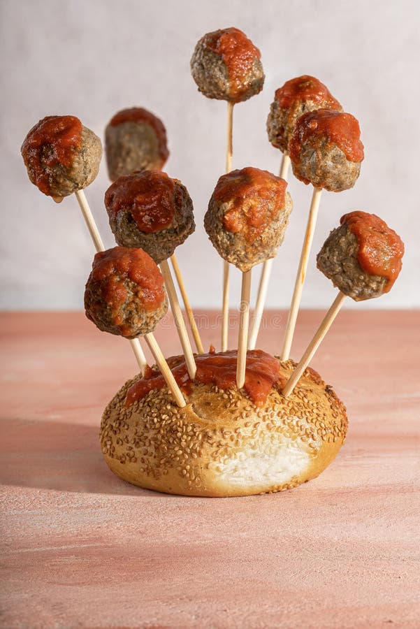 Meatballs on skewers stuck in a bread bun stock image