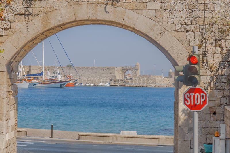 Old town way to exit with blue sea and several docked boat. In Rhodes Greece royalty free stock image