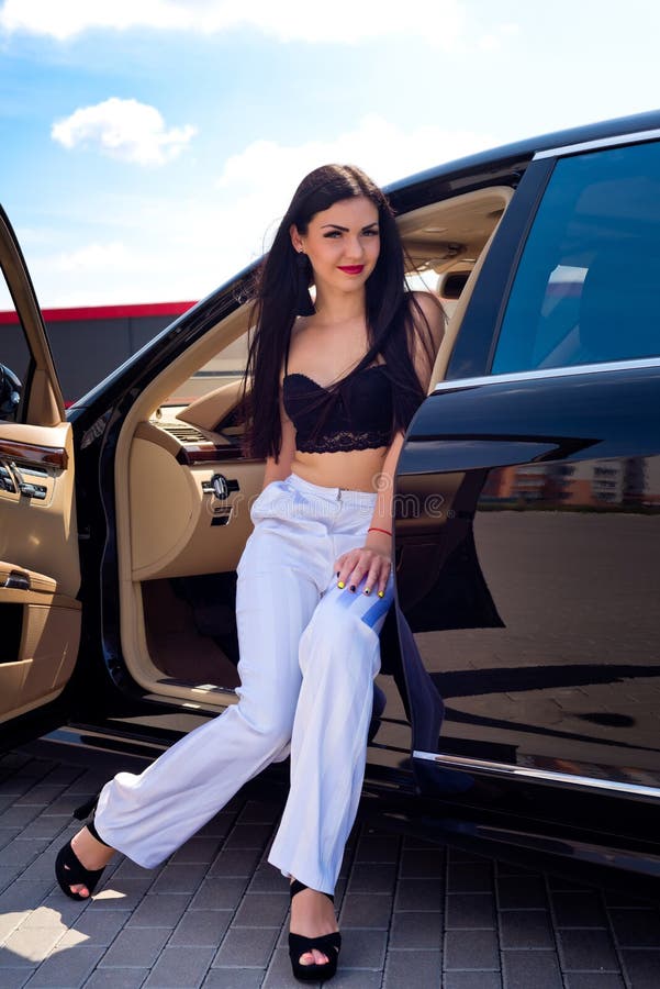 Portrait of a beautiful brunette that sits in a luxury car. People royalty free stock photo