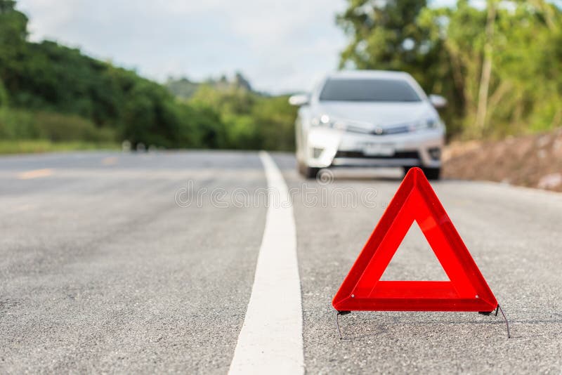 Red emergency stop sign and broken silver car. On the road stock image