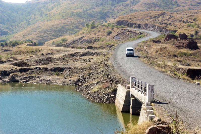 Road travel. Is still a big transport means. An utility suv going through mountainous roads and roush desert terrain outdoors over a bridge stock photos