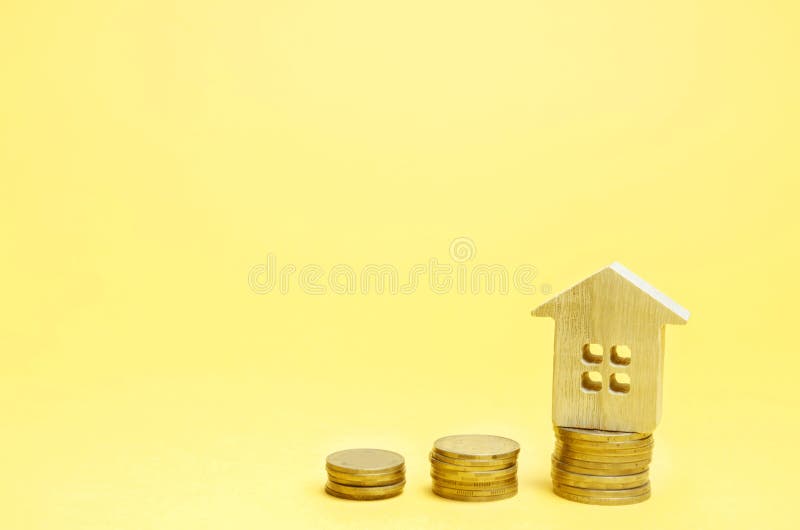 Stacks of coins and a wooden house. The concept of saving money for buying a home. Buy an apartment, real estate. Payment of rent. For the apartment. Property royalty free stock photography