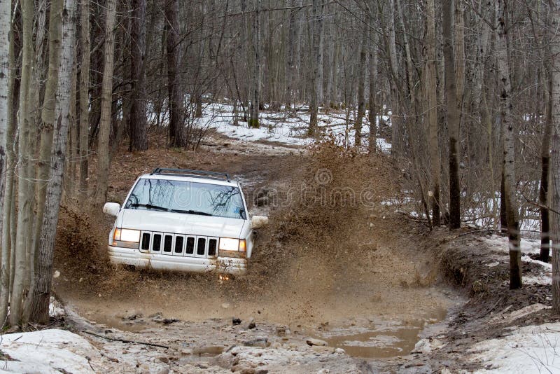 SUV going through deep mud. SUV driving through deep mud in the spring stock images