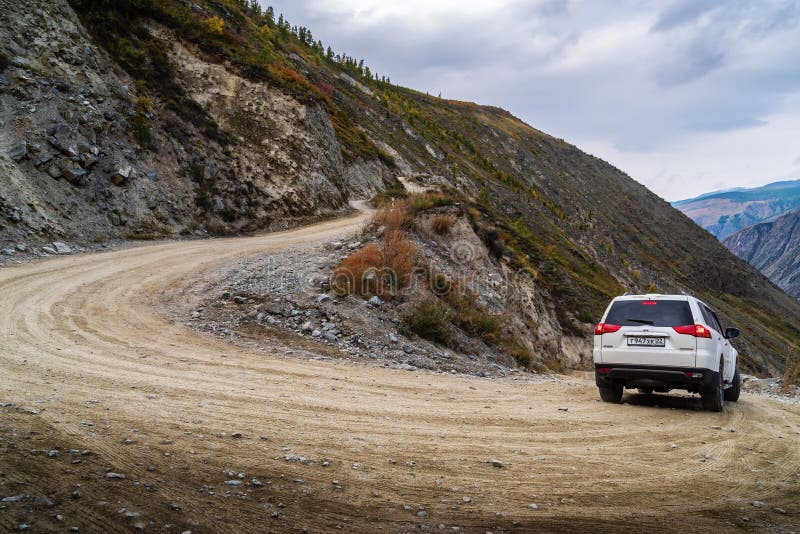 A car going down a mountain road from the Katu-Yaryk pass to the valley of the Chulyshman River. Ulagansky District, Altai Republic, Russia - September, 18, 2019 royalty free stock images