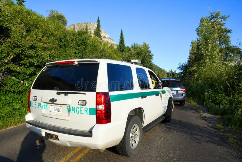 US Park Ranger Truck. GLACIER NATIONAL PARK, MONTANA, USA - July 22, 2017: United States Park Ranger SUV pulls into traffic on Going to the Sun Road in Glacier stock images