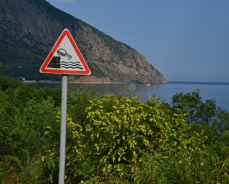 Warning road sign exit to the embankment royalty free stock photo