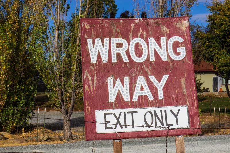 Weathered Wrong Way Exit Sign. Weathered Wooden Wrong Way Exit Only Sign royalty free stock photos