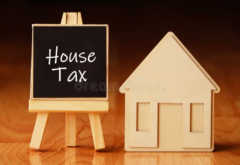 Wooden house stand with a sign house tax. Selling a house or apartment and property. housing and real estate. Real estate sales royalty free stock images