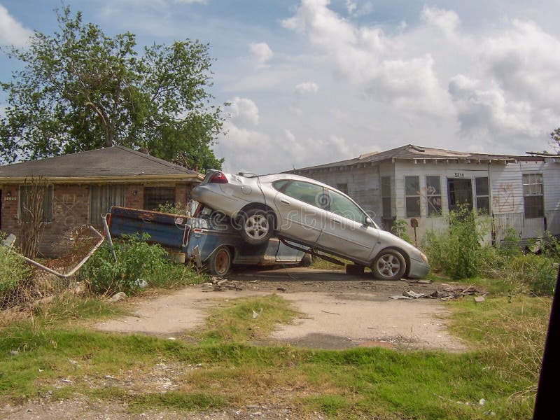Wrecked car on top of truck in front of damaged houses after Hurricane Katrina royalty free stock photos