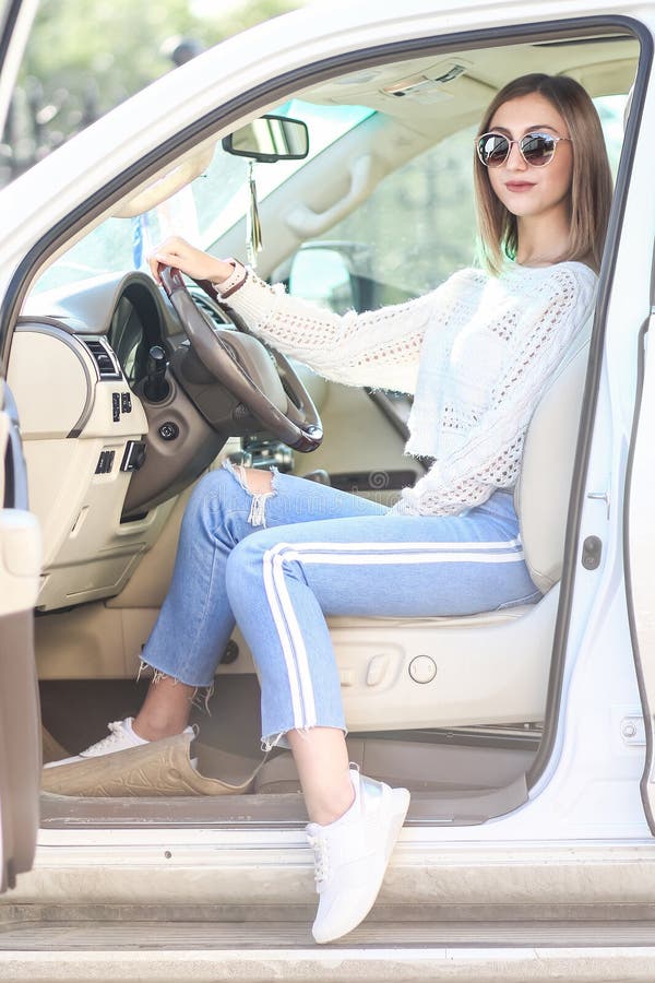 Young girl in the luxury car. Pretty young girl in a casual clothes sitting in the modern luxury off-road car royalty free stock image