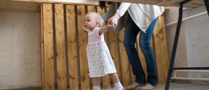 A parent helping their toddler to walk